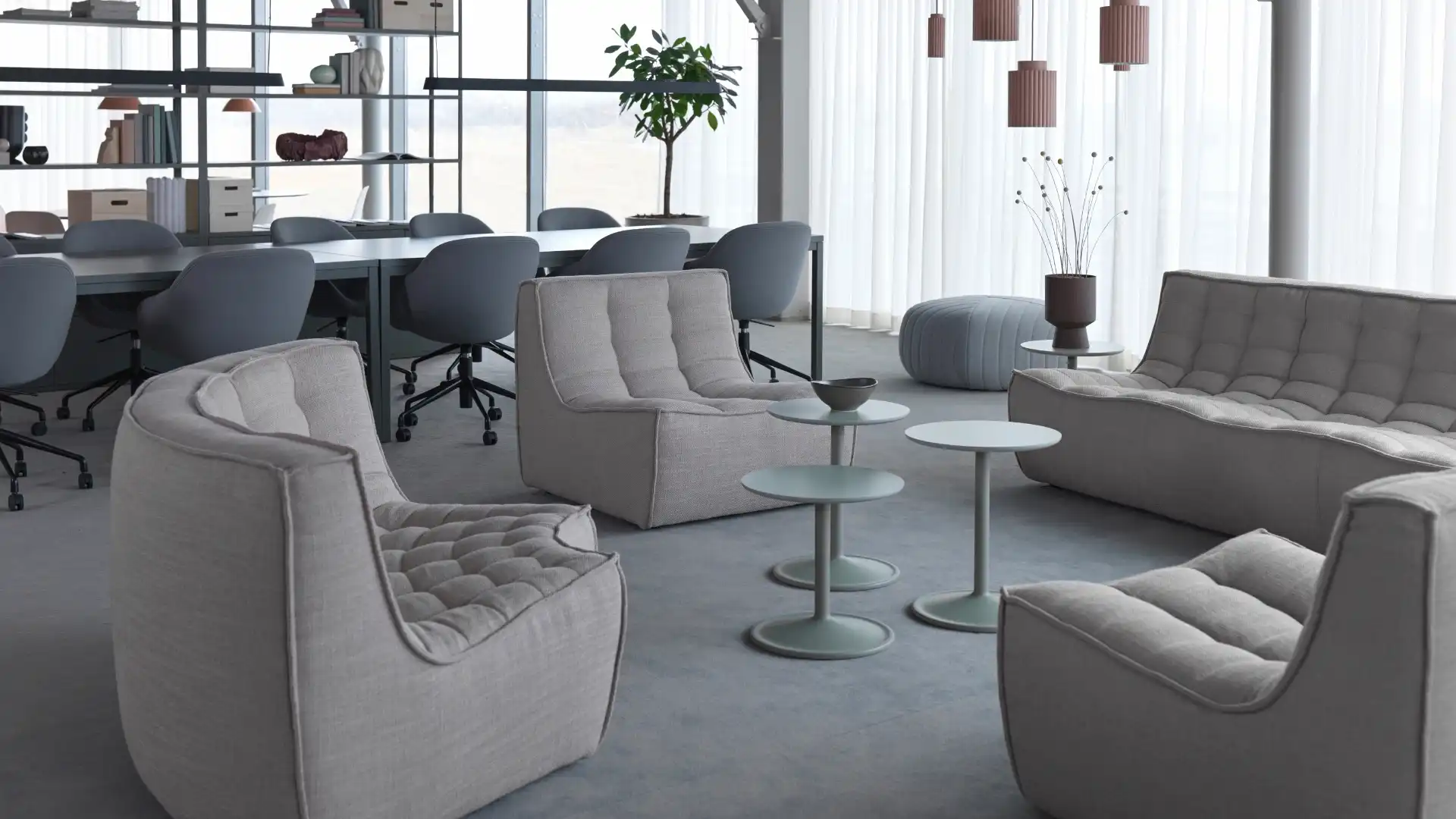 Modern lounge med stora fönster och ett rymligt bord, perfekt för avkoppling och företagsmöten.