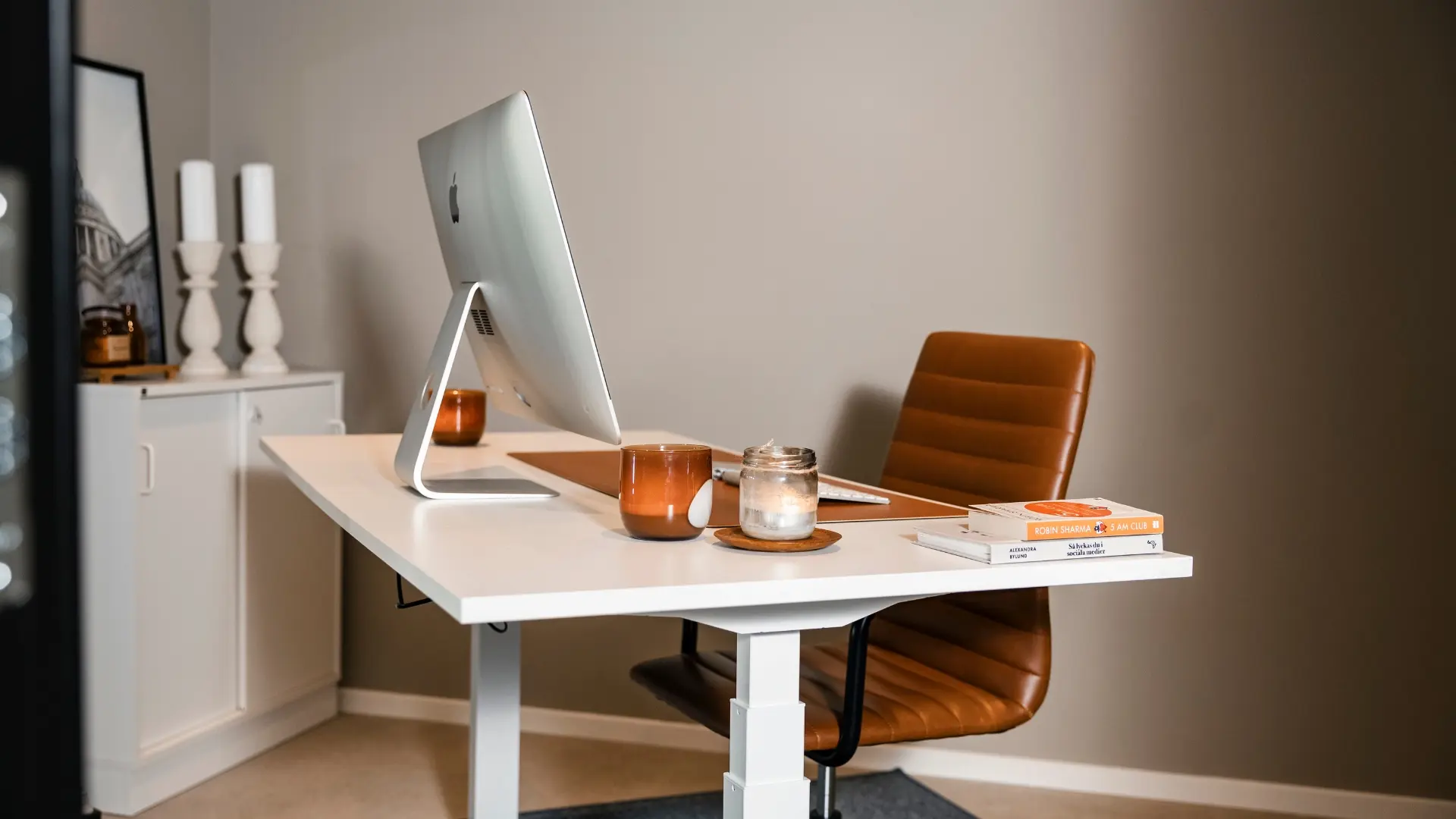 Ett stilrent vitt skrivbord med dator och stol i ett privat kontor, idealiskt för produktivitet och fokus.